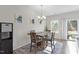 Cozy dining area with a stylish light fixture, artwork, and sliding door access to the backyard at 63 Pale Moss Dr, Clayton, NC 27527