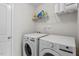 Well-lit laundry room featuring side-by-side washer and dryer and wire rack for storage at 63 Pale Moss Dr, Clayton, NC 27527