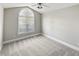 Neutral bedroom featuring a large arched window for lots of natural light and a ceiling fan at 6624 Professor St, Raleigh, NC 27616