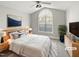 Spacious bedroom featuring a ceiling fan, large window and staged furniture at 6624 Professor St, Raleigh, NC 27616