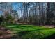 Expansive backyard showcasing a lush green lawn and mature trees creating a serene outdoor environment at 6816 Rainwater Rd, Raleigh, NC 27615