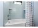 Modern bathtub with tiled walls and shelves, complemented by a stylish shower curtain at 6816 Rainwater Rd, Raleigh, NC 27615
