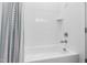 Bright bathroom featuring a tub with white tiled walls and brushed chrome fixtures at 6816 Rainwater Rd, Raleigh, NC 27615