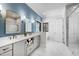 Bathroom with double vanity, marble floors and accent blue wall at 6816 Rainwater Rd, Raleigh, NC 27615