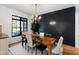 Stylish dining room featuring a wood table, modern chandelier, and a dark accent wall at 6816 Rainwater Rd, Raleigh, NC 27615