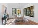 Sunlit dining room with hardwood floors, modern lighting, and large windows overlooking the backyard at 6816 Rainwater Rd, Raleigh, NC 27615