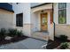Close-up of the home's entry, showcasing a wood door, painted address numbers, and brick accents at 6816 Rainwater Rd, Raleigh, NC 27615