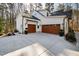A spacious three car garage with wood doors and a large driveway, providing ample parking and storage space at 6816 Rainwater Rd, Raleigh, NC 27615