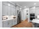 Contemporary kitchen boasts stainless steel appliances, abundant gray cabinetry, and hardwood flooring at 6816 Rainwater Rd, Raleigh, NC 27615