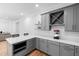 Bright kitchenette with gray cabinetry, stainless steel appliances, and white countertops at 6816 Rainwater Rd, Raleigh, NC 27615