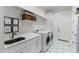 Bright laundry room featuring modern appliances, ample storage, and stylish tile flooring at 6816 Rainwater Rd, Raleigh, NC 27615