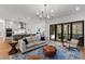 Open concept living room with modern lighting, hardwood floors, and sliding glass doors to an outside deck at 6816 Rainwater Rd, Raleigh, NC 27615