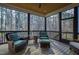 Screened porch with chairs, end table, and lush backyard views at 6816 Rainwater Rd, Raleigh, NC 27615