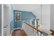 The blue staircase with a white banister features large windows, providing natural light and scenic views at 6816 Rainwater Rd, Raleigh, NC 27615