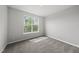 Light-filled bedroom featuring plush carpeting and a large window with natural outdoor views at 88 Ripple Way # 314, Clayton, NC 27520