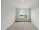 Inviting bedroom with neutral colors, plush carpet, and a window showcasing a scenic outdoor view at 88 Ripple Way # 314, Clayton, NC 27520