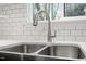 Close-up of a stainless steel kitchen sink with modern faucet and subway tile backsplash at 1016 N Bend Dr, Raleigh, NC 27609