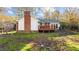 Cozy home featuring a wooden deck, brick chimney, and inviting backyard space at 104 Seaman St, Oxford, NC 27565