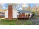 Back of house featuring a brick chimney and a wooden deck, perfect for outdoor entertaining at 104 Seaman St, Oxford, NC 27565