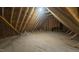 Unfinished attic space with exposed wooden beams and plywood flooring, offering potential for customization at 105 Leisure Ln, Louisburg, NC 27549
