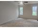 Spacious bedroom with neutral carpet, ceiling fan, and natural light from two windows at 105 Leisure Ln, Louisburg, NC 27549