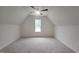 Spacious bonus room with plush carpeting, ceiling fan, and natural light from the window at 105 Leisure Ln, Louisburg, NC 27549