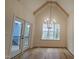 Bright dining room with hardwood floors, vaulted ceilings, a chandelier, and patio access at 105 Leisure Ln, Louisburg, NC 27549