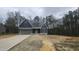 Charming new construction home with a gray garage door, and a partially landscaped yard at 105 Leisure Ln, Louisburg, NC 27549