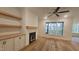 Open living room featuring hardwood floors, a fireplace, built-in shelving, and a ceiling fan at 105 Leisure Ln, Louisburg, NC 27549