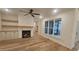 Spacious living room featuring hardwood floors, a fireplace, built-in shelves, and a large window at 105 Leisure Ln, Louisburg, NC 27549