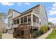 Home exterior features a covered porch, a patio, yard space, and stairs to a deck at 105 Mystic Quartz Ln, Holly Springs, NC 27540