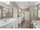 Elegant primary bathroom with double vanities, tiled flooring, walk-in shower, and a soaking tub at 105 Mystic Quartz Ln, Holly Springs, NC 27540