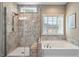 Modern bathroom featuring glass shower, soaking tub, and tiled accents at 105 Mystic Quartz Ln, Holly Springs, NC 27540