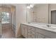 Well-lit bathroom with double sink vanity, framed mirrors, and a shower with glass doors at 105 Mystic Quartz Ln, Holly Springs, NC 27540