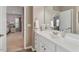 Bright bathroom featuring a white vanity with a white sink and a view into the main bedroom at 105 Mystic Quartz Ln, Holly Springs, NC 27540