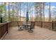 Wooden deck with seating area offers a tranquil outdoor space surrounded by mature trees at 105 Mystic Quartz Ln, Holly Springs, NC 27540