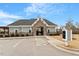 Community clubhouse with stone entry, parking and manicured landscaping under a bright blue sky at 105 Mystic Quartz Ln, Holly Springs, NC 27540