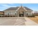 Community clubhouse with stone entry, parking and manicured landscaping under a bright blue sky at 105 Mystic Quartz Ln, Holly Springs, NC 27540