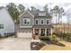 Charming two-story home showcasing a red front door, manicured lawn, and inviting curb appeal at 105 Mystic Quartz Ln, Holly Springs, NC 27540