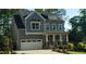 Charming two-story home featuring stone accents, a covered porch, and an attached two-car garage at 105 Mystic Quartz Ln, Holly Springs, NC 27540