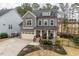 Charming two-story home showcasing a red front door, manicured lawn, and inviting curb appeal at 105 Mystic Quartz Ln, Holly Springs, NC 27540