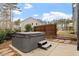 Relaxing backyard featuring a hot tub, privacy fence, and stone paver accents at 105 Mystic Quartz Ln, Holly Springs, NC 27540