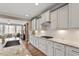 A kitchen features white cabinetry, granite counters, stainless appliances, and hardwood floors at 105 Mystic Quartz Ln, Holly Springs, NC 27540
