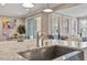 Kitchen island with sink and granite countertops, dining area, and adjacent living area at 105 Mystic Quartz Ln, Holly Springs, NC 27540
