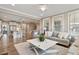 Living Room open to the kitchen with hardwood floors, fireplace, neutral colored furniture and lots of natural light at 105 Mystic Quartz Ln, Holly Springs, NC 27540