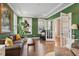 Bright living room featuring green walls, hardwood floors, stylish furniture and natural light from many windows at 105 Mystic Quartz Ln, Holly Springs, NC 27540