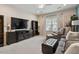 Living room with comfortable seating, ceiling fan, and large window offers a relaxing atmosphere at 105 Mystic Quartz Ln, Holly Springs, NC 27540