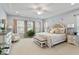 Serene Primary suite with tray ceiling, upholstered bed, sitting area, and neutral color palette at 105 Mystic Quartz Ln, Holly Springs, NC 27540