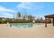 Community pool with lounge furniture and pergola surrounded by a black fence and tall trees at 105 Mystic Quartz Ln, Holly Springs, NC 27540
