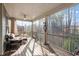 Screened porch with outdoor furniture offers a relaxing view of wooded backyard at 105 Mystic Quartz Ln, Holly Springs, NC 27540